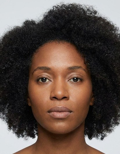 Biometrically cropped ID photo of a woman with full, curly hair.