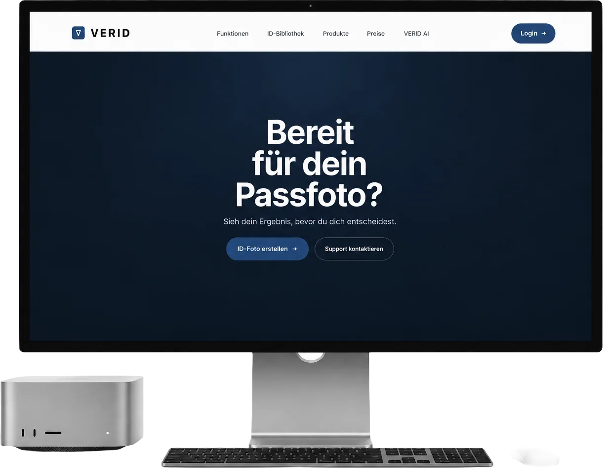 Großer Monitor mit Tastatur, Maus und Mac Studio auf einem hellen Tisch. Auf dem Bildschirm der Abschnitt von verid.at mit der Frage „Bereit für dein Passfoto?“, dem Satz „Sieh dein Ergebnis, bevor du dich entscheidest.“ und den Schaltflächen „Passfoto erstellen“ und „Support kontaktieren“.